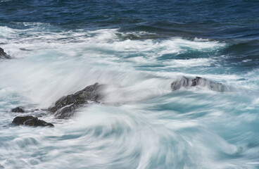 Waves hitting volcanic shoreline