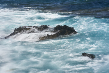 Fototapeta premium Waves hitting volcanic shoreline