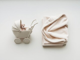 White baby stroller toy and soft blanket on white background, minimalist style