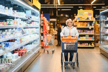 Portrait of happy senior woman shopper in supermarket.