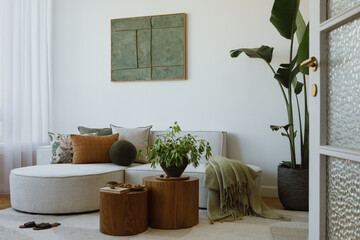 Cozy modern living room with green accents, round wooden coffee tables and soft pillows on a light...