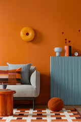 Modern living room with orange wall, grey sofa, blue shelf, geometric rug and minimalist furniture...