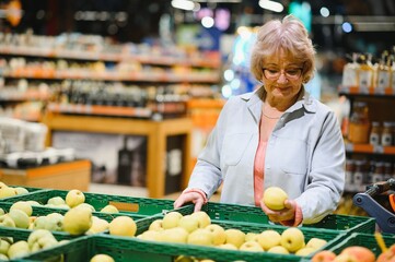 Senior woman buying fresh fruits at the market. Shopping food concept