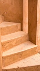 Tan Stone Spiral Staircase Against a Wall