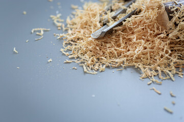 Wood shavings next to chisels on background