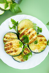 Fried zucchini slices on a green background