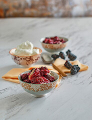 blackberry cobbler topped with whipped cream and fresh blackberries