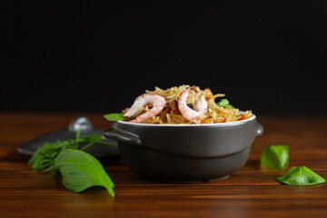 Cooked rice with shrimps and vegetables on black