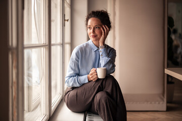 Woman Relaxing by Window With a Cup of Coffee