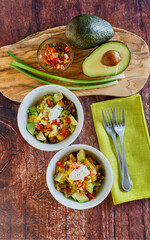 breakfast burrito bowl with eggs, chorizo, avocado, green salsa, sour cream and chopped tomato