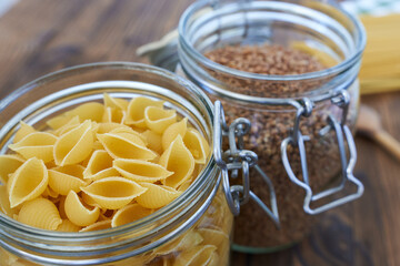 raw pasta in a glass jar on a wooden background close-up