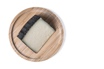 Close-up of a wedge of semi-cured cow's cheese isolated on white background