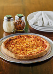 whole cheese pizza with grated parmesan and red pepper flakes