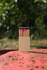 matchbox on red old iron background. matches with pink sulfur