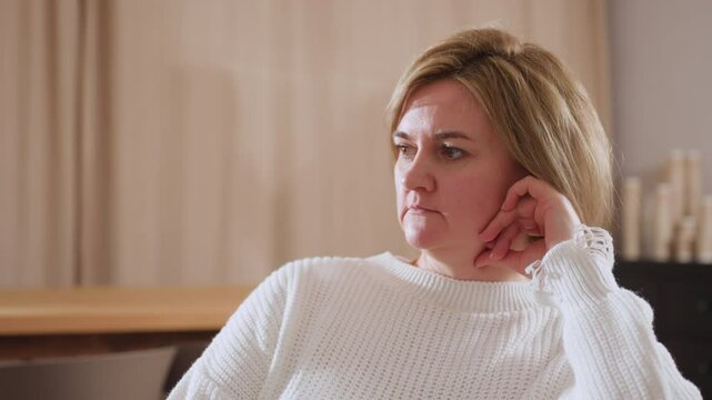 Close up of attentive listener resting her head on hand while nodding during therapy session, showing active engagement, empathy, and thoughtful presence in calm and comfortable indoor setting