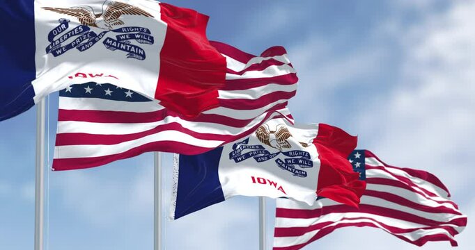 Iowa state flag waving in the wind with the US flag on a clear day
