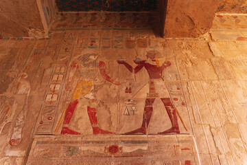 Ancient egyptian pharaoh receiving offerings in a colorful wall relief