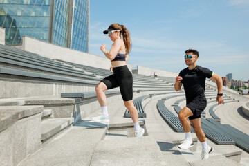 Couple enhances fitness experience by running up outdoor steps on a sunny day