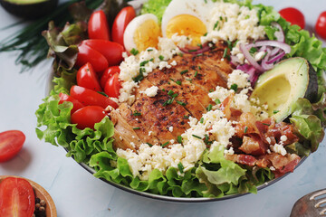 A bowl with cobb salad, traditional American dish