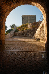 Entrance gate below the Palace of the Counts with a view of the south tower of the castle of Ourém in Portugal.