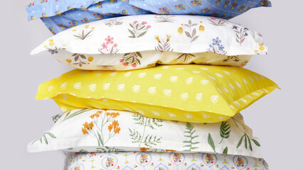 Colorful decorative pillows stacked with floral patterns, enhancing a cozy living space.