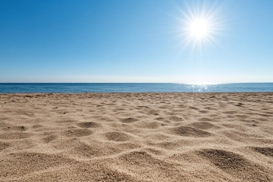 A clear blue sky with the sun beaming down, sun rays visibly radiating outward in a starburst effect over a calm ocean
