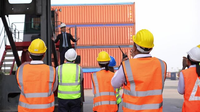 Logistics manager giving public speech and showing support to construction worker at container warehouse. Leader announcing good news. Successful corporate people and business.