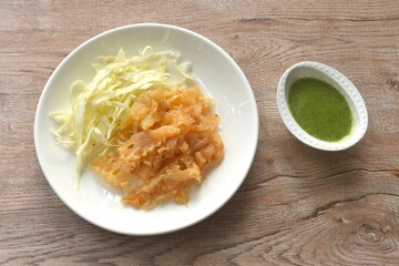 boiled jellyfish with slice cabbage on plate dipping Thai spicy and sour seafood sauce