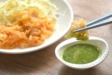 boiled jellyfish with slice cabbage on plate dipping Thai spicy and sour seafood sauce