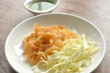 boiled jellyfish with slice cabbage on plate dipping Thai spicy and sour seafood sauce