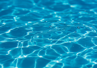 Obraz premium Glistening azure dreams: Sunlit water's soft ripples and bubbles creating a calming, transparent, blurry liquid canvas.