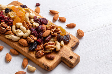 a wooden cutting board topped with nuts and dried fruit