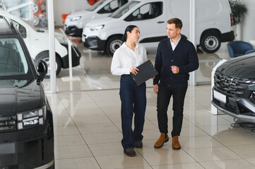 Man customer male buyer client consult with salesman signs documents choose auto
