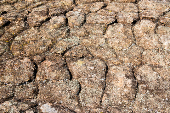 Detail shot of heavily textured and patterned rock with cracks