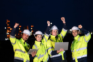 Group of engineer raising hands up for finish working night shift at petrochemical refinery oil industrial.