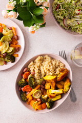 A nutritious breakfast spread includes quinoa, baked sweet potatoes, carrots, zucchini, broccoli, beans, tender chicken breast, and a vibrant fresh salad, ready for enjoyment