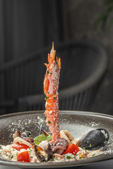 A gourmet seafood risotto elegantly presented with a vertical skewer of shrimp, surrounded by...