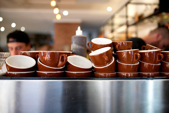 Brown coffee cups stacked on coffee machine at cafe
