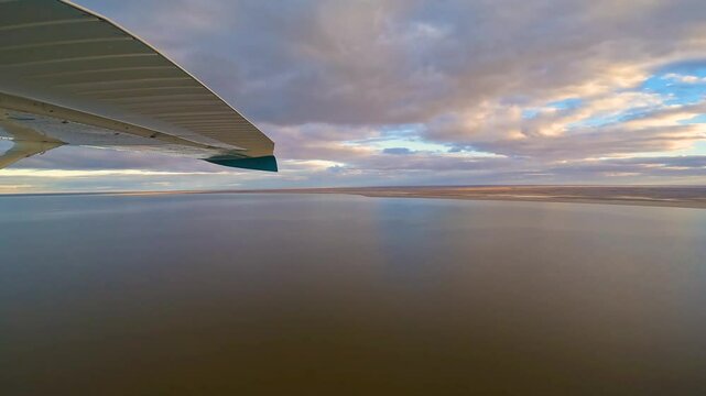 Experience a breathtaking aerial perspective of Lake Eyre in South Australia's outback. Witness the rare and beautiful sight of the lake filling with water, captured from a Cessna 206 aircraft window.