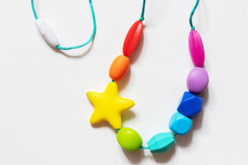 Colorful silicone baby teether necklace featuring various shapes and a star design, intended for...