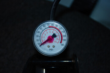 Close-up of a pressure gauge with PSI and BAR units, with the needle at zero. An image for...