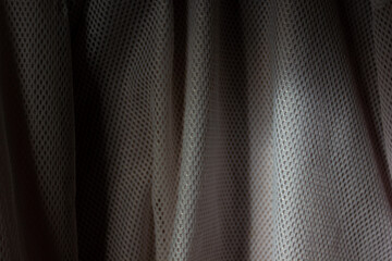 Close-up texture of a grey mesh fabric with folds. An abstract, modern background for technical or...