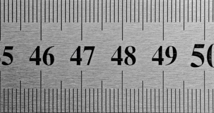 Metal Ruler Close-Up. Video featuring a detailed view of a sleek metal ruler with precise millimeter markings, captured in high clarity.