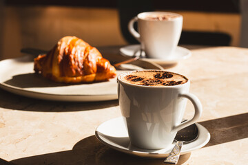 Saturday afternoon in a bakery having coffee and a croissant.