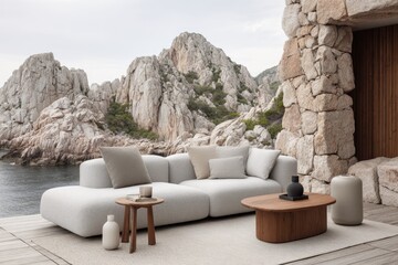 Outdoor sectional sofa with wooden side tables against a backdrop of rugged mountains and the sea