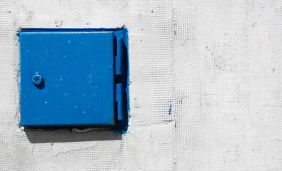 Blue small steel door on concrete wall