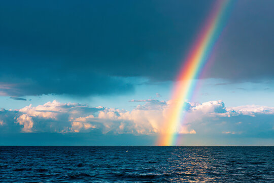 a rainbow is shining in the sky over the ocean
