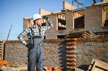 Portrait of a builder in the process of working on a construction site outdoors