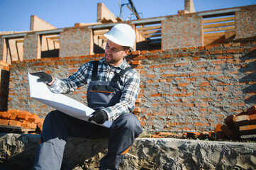 Installing brick wall. Construction worker in uniform and safety equipment have job on building