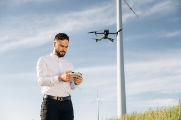 Controlling the drone. Engineer in field checking on wind turbine production